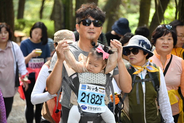 ▲ 한 참가자가 아이를 안고 산길을 걷고 있다. /김구연 기자 sajin@idomin.com<br /><br />