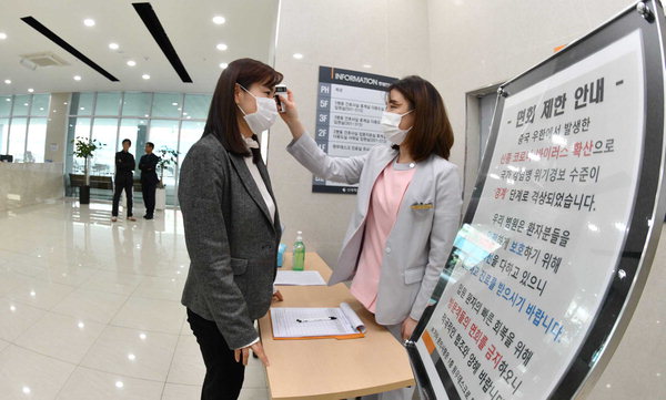 ▲ 신세계요양병원 입구에서 코로나19 예방을 위한 체온 검사를 하고 있는 의료진. /김구연 기자