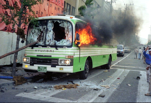 ▲ 1987년 6월 10일 마산 불종거리 대신증권 앞에서 전경버스가 불타고 있다. /6월항쟁정신계승경남사업회