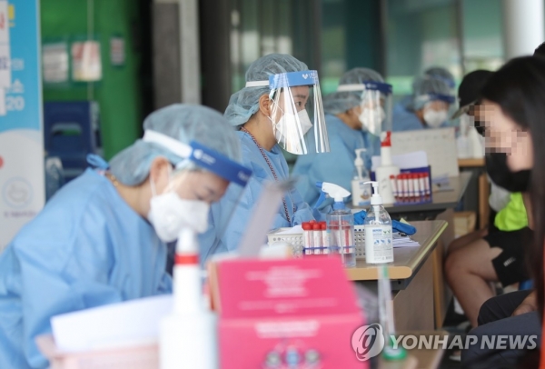 9일 오전 광주 서구청 선별진료소에서 의료진이 코로나19 검사를 위해 문진을 하고 있다./연합뉴스