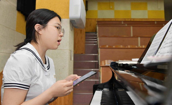 ▲ 윤서림 학생이 피아노 앞에서 노래를 부르고 있다.  /김구연 기자 sajin@idomin.com