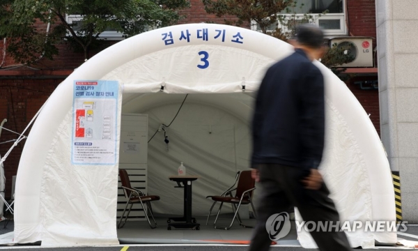 19일 서울 국립중앙의료원 코로나19 선별진료소에서 한 시민이 텅빈 검사대기소 앞을 지나고 있다. /연합뉴스