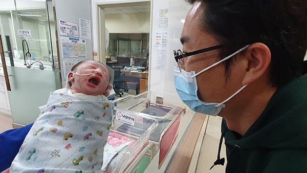 2021년 1월 1일 오후 2시 50분에 태어난 창원의 첫 아기인 하리보(태명)를 아빠 하지철 씨가 행복한 표정을 바라보고 있다. /한마음창원병원