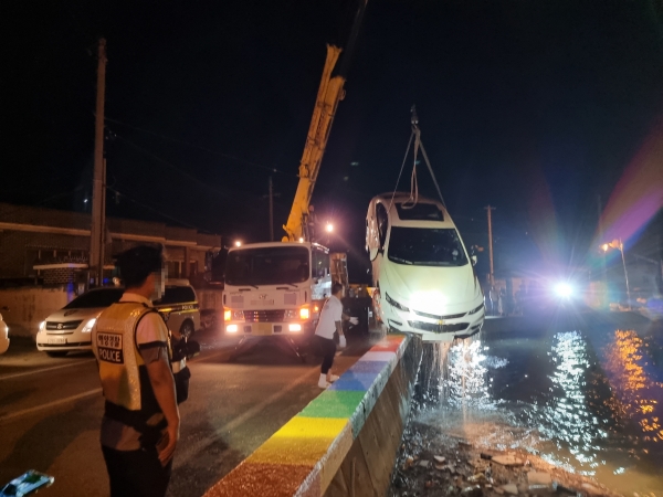 지난 10일 오후 사천시 한 해안도로에서 바다로 추락한 차량을 크레인으로 인양하고 있다. /통영해양경찰서