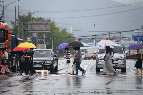▲ 25일 오전부터 다시 비가 내리고 있다. 이날 시민들이 우산을 들고 창원시 마산회원구 창원NC파크 앞 건널목을 지나가고 있다.  /김구연 기자 sajin@idomin.com