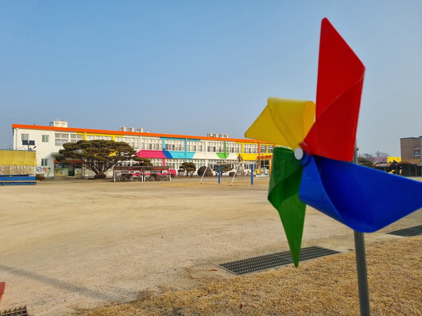 ▲ 함안 중앙초등학교 입구에 무지갯빛 바람개비가 팔랑이고 있다.  /이창우 기자
