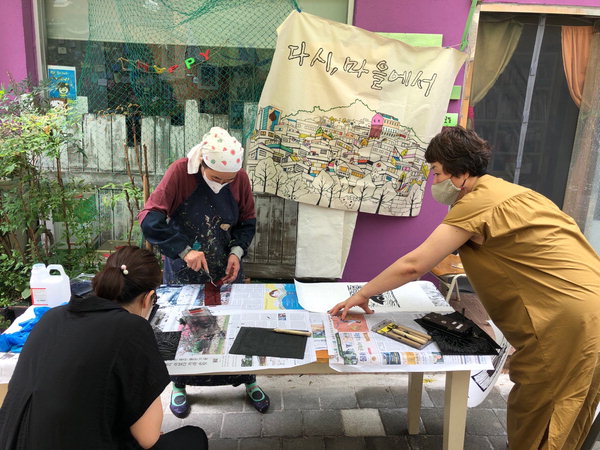 ▲ 정순옥(왼쪽 둘째) 작가가 지난해 여름 마을탐방대 '누비도' 프로그램의 하나로 주민과 함께 판화 체험을 하고 있다. /김경년 씨