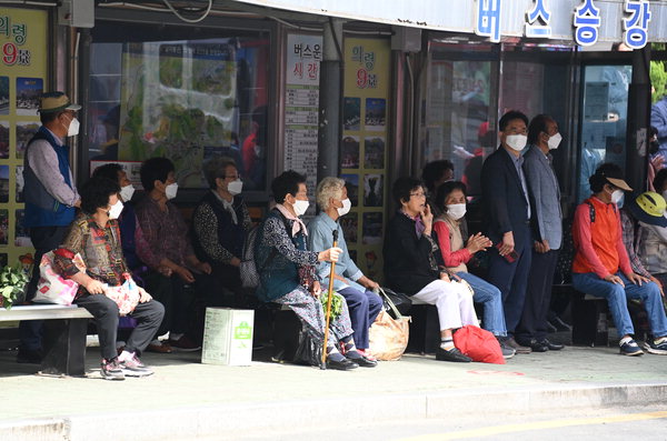 ▲ 28일 의령군 의령읍 의령우체국 버스승강장에서 어르신들이 버스를 기다리며 6.1전국동시지방선거에 출마한 한 후보의 연설을 듣고 있다.  /김구연 기자 sajin@idomin.com
