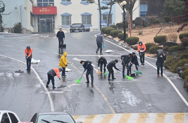 21일 창원시 마산회원구 내서읍 마산대학교 오르막 길에서 학교 관계자들이 얼음을 없애고 있다. /김구연 기자