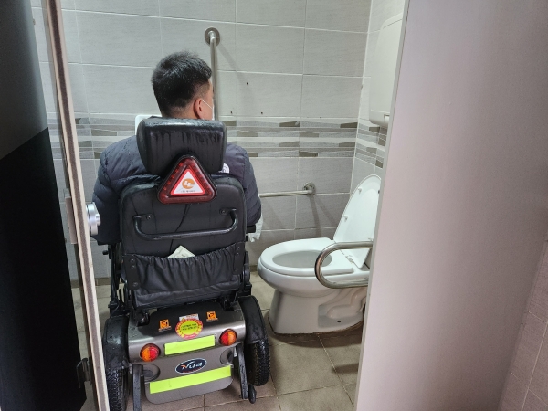 박덕근 진해장애인인권센터 활동가가 23일 오전 경화역 장애인화장실을 살펴보고 있다. 내부가 좁아 휠체어를 돌릴 공간이 나오지 않는다. /박신 기자