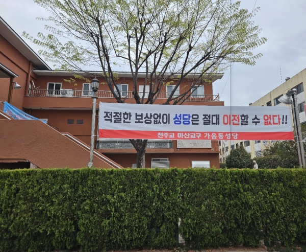 지난 22일 창원시 성산구 가음동 성당 앞에 신축 이전 공사비를 요구하는 펼침막이 걸렸다. /이창우 기자