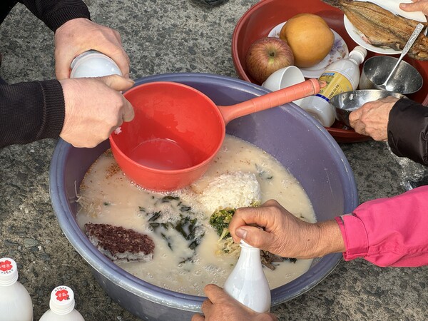 거제 죽림마을 별신굿 중 띠뱃놀이에서 바다에 바칠 술을 만드는 주민들./이서후 기자