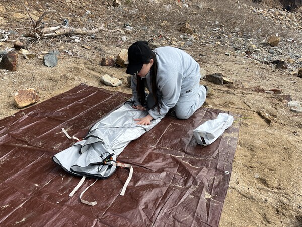 김현경 씨가 텐트를 접어 부피를 줄이고 있다. /주성희 기자 
