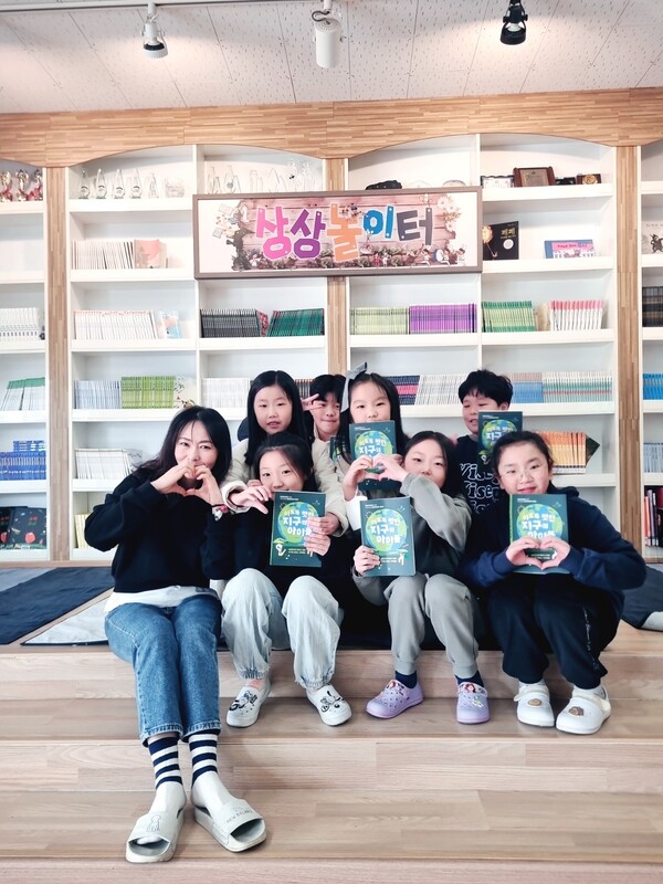 임성화(맨 왼쪽) 창원 용남초등학교 교사가 학생들과 함께 책 '이토록 멋진 지구의 아이들'을 들고 기념사진을 찍고 있다. /임성화 교사