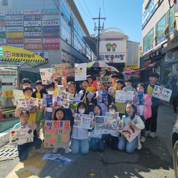 창원 용남초등학교 학생들이 인근 반송시장에서 '용기 내 프로젝트'로 일회용품 사용 줄이기를 홍보하고 있다. /임성화 교사
