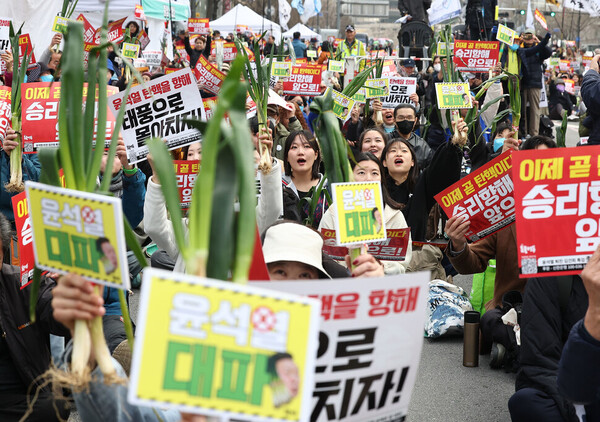 지난달 30일 서울 중구 세종대로에서 열린 ‘83차 촛불 대행진' 집회에서 참가자들이 대파를 들고 윤석열 정부를 규탄하고 있다. /연합뉴스