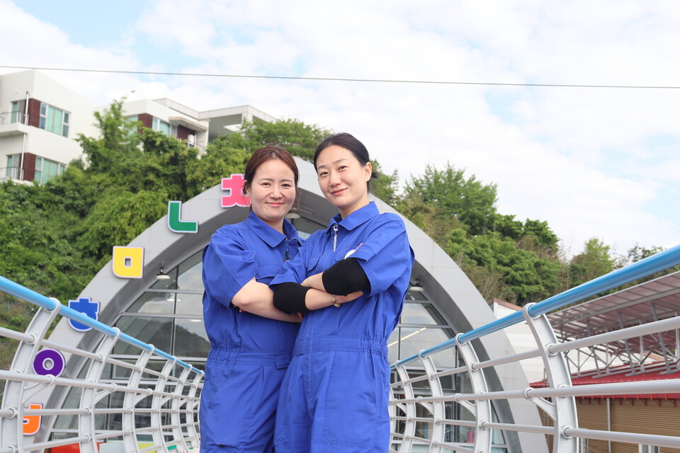 삼천포블루스를 운영하고 있는 김보경(왼쪽) 대표와 양소윤 이사가 사천에 있는 청년문화에비뉴를 배경으로 사진을 찍고 있다. /주성희 기자