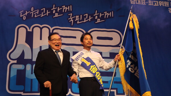 27일 더불어민주당 경남도당 1차 당원대회에서 신임 도당 위원장으로 선출된 송순호 후보가 당 깃발을 들고 있다. /최환석 기자