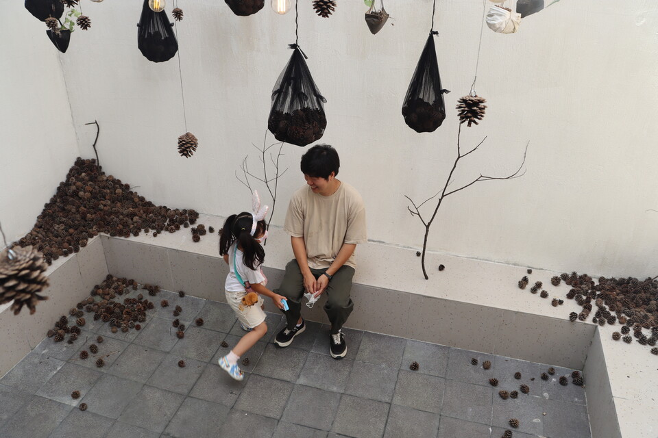 정호 작가가 지난 13일부터 다음달 1일까지 개인전 〈숢; 느린 호흡〉을 창원 인사이드갤러리에서 한다. 전시장 입구 설치 작품 속에 큰 딸과 함께 있는 정호 작가. /주성희 기자