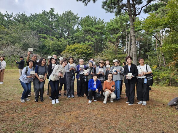 쿠온출판사 김승복 대표와 번역가·일본 독자들이 박경리 선생 묘소를 찾아 일본어 완역본을 헌정하고 나서, 박 선생 묘소 앞에서 통영 바다를 바라보며 기념사진을 찍고 있다. /정봉화 기자