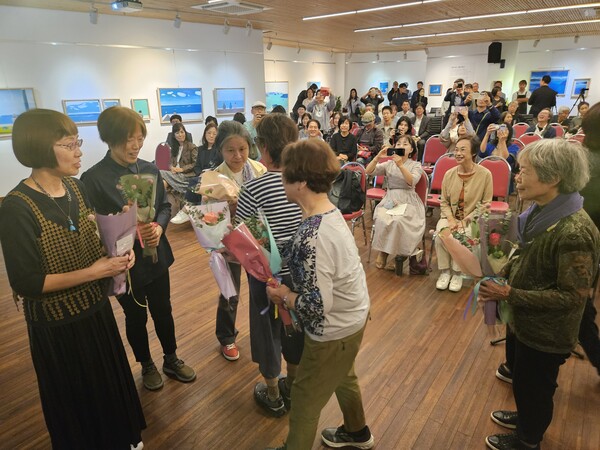 왼쪽부터 공동 번역가 시미즈 지사코, 요시카와 나기, 편집인 후지이 히사코 씨가 일본 독자들에게 20권 완역 축하와 감사 뜻을 담은 꽃 20송이를 받고 있다. /정봉화 기자