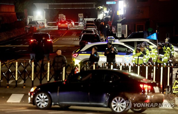비상 계엄이 선포된 3일 밤 서울 용산 대통령실·국방부 청사 입구 앞에 바리케이트가 설치된 가운데 차량들이 청사 입구로 향하고 있다. /연합뉴스