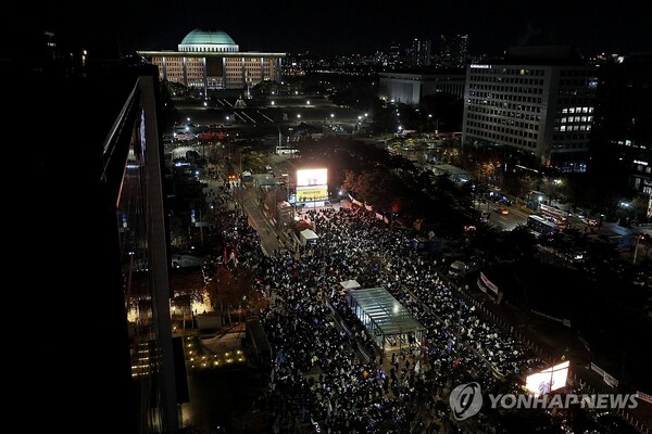 8일 오후 서울 여의도 국회 앞에서 열린 윤석열 탄핵 및 구속을 촉구하는 촛불문화제에서 참가자들이 관련 손팻말과 응원봉을 들고 있다. /연합뉴스