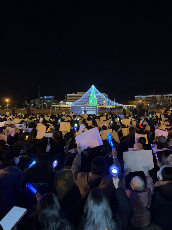 윤석열퇴진경남운동본부는 8일 오후 창원시청 앞 광장에서 시민대회를 열었다. 집회 현장에 앉아있는 시민들이 응원봉을 흔들고 있다. /주성희 기자