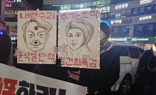 한 자매가 윤석열 김건희 캐리커처를 직접 그려 만든 손팻말을 들고 있다. /정봉화 기자
