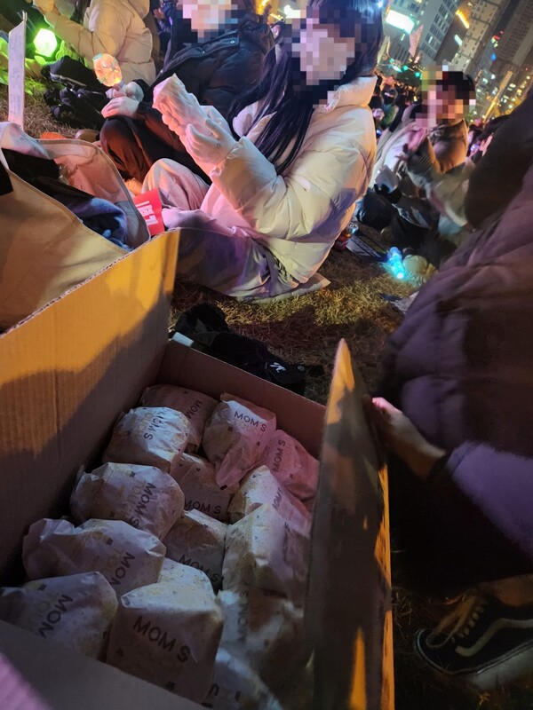 NC 박민우 선수 가족과 지인이 집회 현장에서 참석자들에게 햄버거를 나눠준 모습. /우귀화 기자