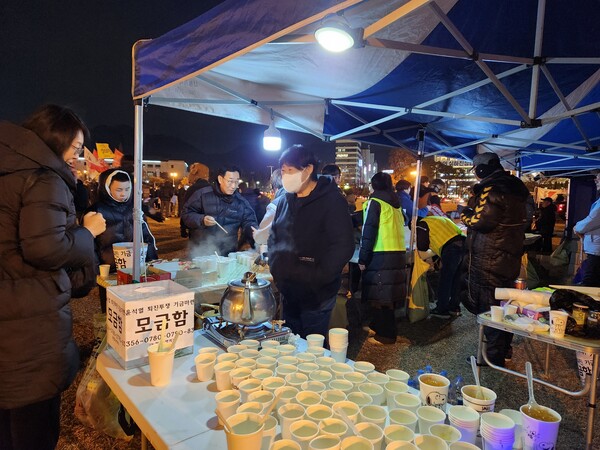 시민단체, 노조 등으로 이루어진 자원봉사자들이 지난 9일 창원광장에서 열린 시민대회에서 시민들에게 차를 나눠주고 있다. /박신 기자