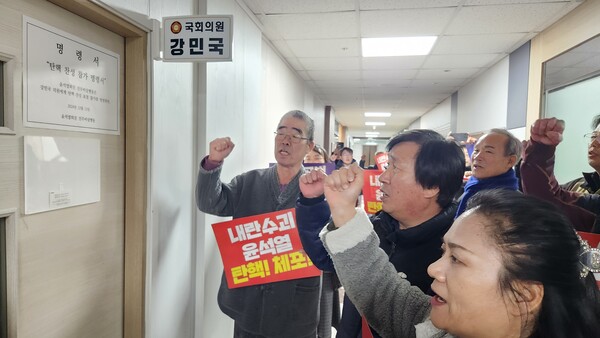 윤석열퇴진 진주비상행동이 12일 굳게 잠긴 강민국 국회의원 사무소 입구 문에 '탄핵 찬성'을 요구하는 명령서를 붙였다. /허귀용