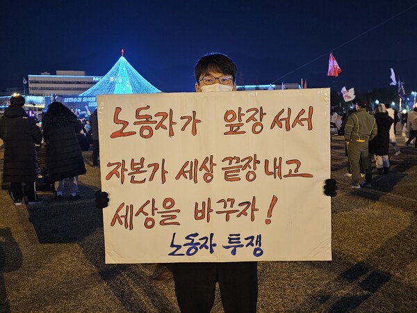 창원 성산구에 사는 김희근 씨가 11일 오후 6시 20분께 창원시 성산구 중앙동 창원시청 맞은편 창원광장에서 팻말을 들고 있다. /최석환 기자
