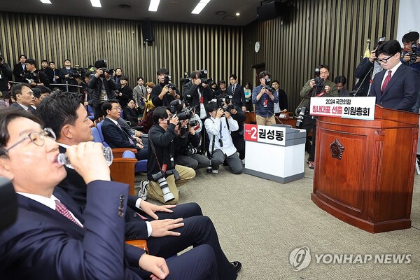 12일 오전 국회에서 열린 국민의힘 의원총회에 한동훈 대표가 참석해 발언대에 선 가운데 국민의힘 권성동 의원이 물을 마시고 있다. /연합뉴스