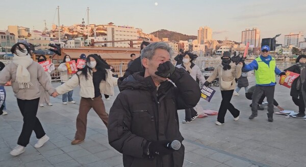 14일 윤석열 탄핵소추안 가결 소식이 전해지자 통영시민 시국대회 참가자들이 강강술래를 하며 기쁨을 나누고 있다. 시국대회에서 줄곧 진행을 맡아온 이동호 씨가 감격해 하며 눈시울을 붉히고 있다. /정봉화 기자