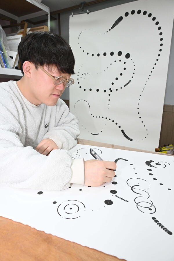 작업실에서 특유의 도형을 그리는 방상환 작가. /김구연 기자   