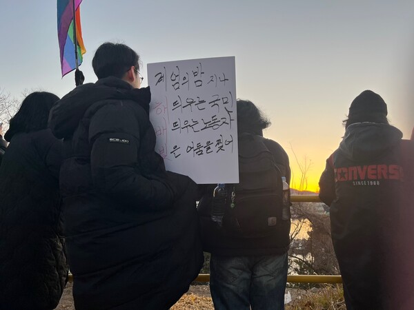 1일 거제 옥포조각공원에서 조선소 하청 노동자들과 시민듣이 일출을 보고 있다. /김다솜 기자 