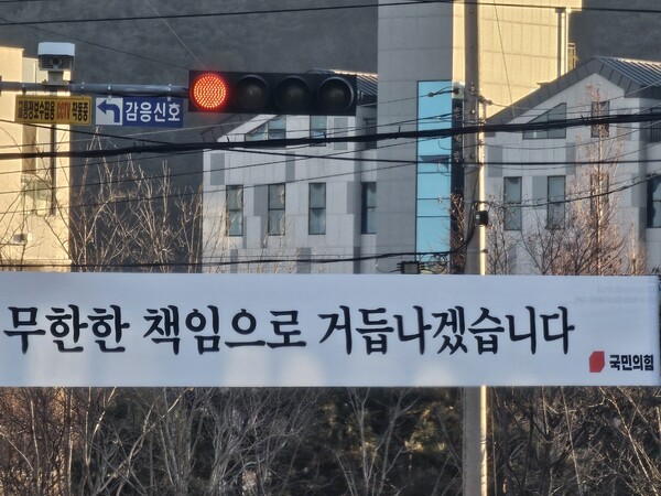 윤석열 대통령 12.3 내란 사태 이후 국민의힘은 '무한한 책임'으로 거듭나겠다고 읍소했지만, 실제로는 일부 강성 지지층에 집중하는 행태만 보이고 있다. 현수막 위 신호등 빨간불이 국민의힘 미래를 상징하는 듯하다. /사진 독자 윤병렬 씨