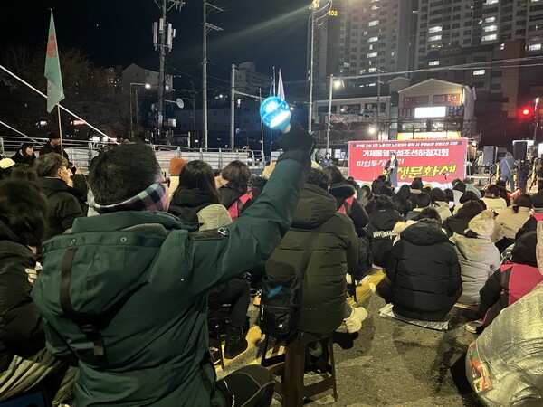 한 연대자가 2024년 마지막 날 한화오션 거제사업장 서문다리에서 열린 투쟁 문화제에서 응원봉을 흔들고 있다. /김다솜 기자 