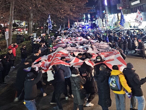 11일 오후 7시 창원시 의창구 봉곡동 국민의힘 경상남도당 앞에서 시민들이 국민의힘 의원 얼굴이 새겨진 현수막을 찍는 단체행동을 하고 있다. /최석환 기자