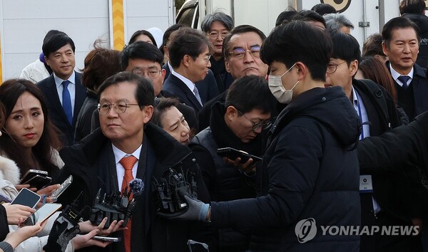 14일 오후 윤석열 대통령의 법률대리인인 윤갑근 변호사가 윤 대통령의 탄핵심판 첫 변론기일을 마치고 서울 종로구 헌법재판소 심판정을 나서면서 보도진 질문에 답변하고 있다. 오른쪽으로 탄핵소추단 정청래 단장(오른쪽)이 지나가고 있다. /연합뉴스
