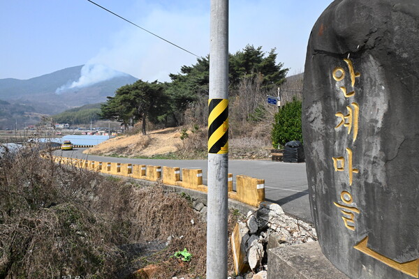 하동군 옥종면 안계마을 뒷산에 연기가 피어오르고 있다. 소방헬기는 진화를 하고 있다.