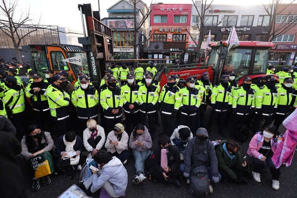 26일 서울시 경복궁 인근에서 경찰들이 전국농민회총연맹 소속 트랙터를 둘러싸고 있는 가운데 시민들과 대치하고 있다. /연합뉴스