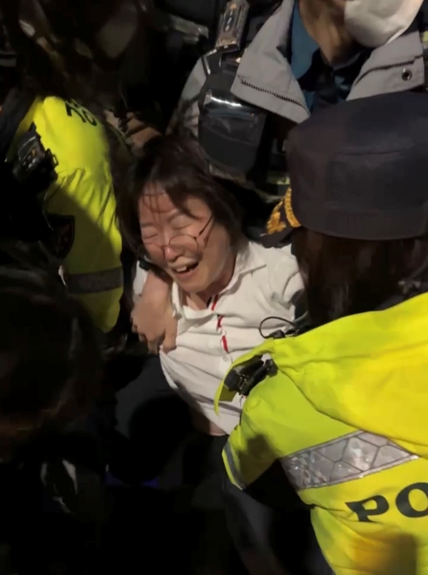 정혜경(진보당·비례) 국회의원이 26일 밤 서울 광화문 앞에서 농민 트랙터를 탈취하려는 경찰 위법성에 문제제기를 하는 과정에 폭력 진압을 당하고 있다. /정혜경 의원실