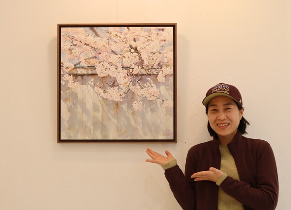 고향 진해의 벚꽃을 그리는 편지현 작가가 작품을 소개하고 있다. 그는 매년 군항제 기간이면 공간 도자랑에서 작품을 전시한다. /백솔빈 기자