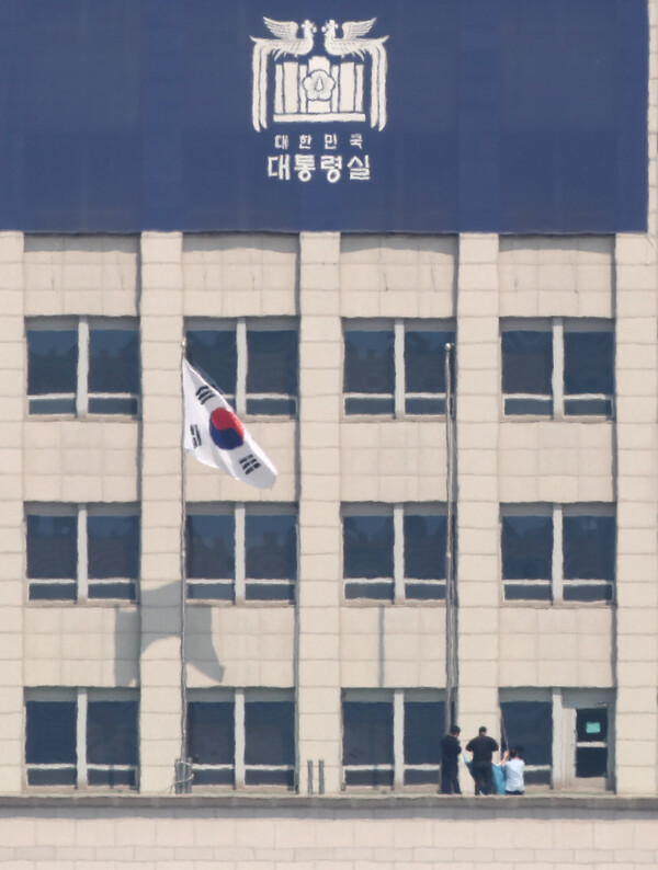  헌법재판소가 윤석열 대통령 파면을 선고한 4일 서울 용산구 대통령실에서 관계자들이 봉황기를 내리고 있다. /연합뉴스