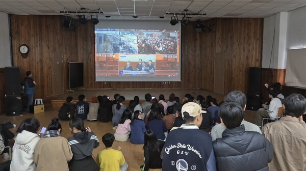 4일 오전 간디고 전교생 90명이 강당에 모여 윤석열 대통령 탄핵 심판 선고 생중계를 시청하고 있다. /문정민 기자