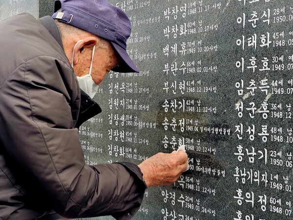 4.3사건으로 아버지를 잃은 송재봉 씨가 지난 3일 오전 제주4.3평화공원에서 희생자 비석에 적힌 선친 이름을 물티슈로 닦고 있다. /최석환 기자 