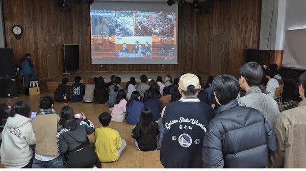 산청 간디고등학교 전교생 90명이 4일 오전 강당에 모여 대통령 탄핵 심판 선고 생중계를 시청하고 있다. /문정민 기자