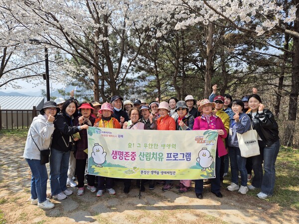 김해돌봄지원센터가 분성산 생태숲 체험 프로그램에 참여하고 기념촬영을 하고 있다. /김해시
